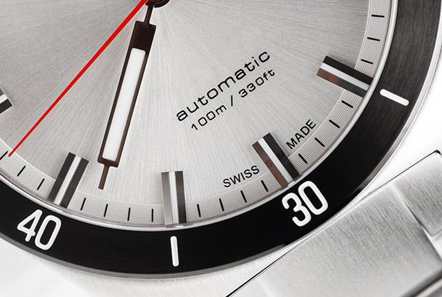 The image is a photograph of a wristwatch. The watch is made of stainless steel and has a silver dial with black and white markings. The image is a photograph of a wristwatch. The watch is made of stainless steel and has a silver dial with black and white markings.