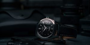 The image is a photograph of a wristwatch. It is a black Seiko Presage watch with a black leather strap.